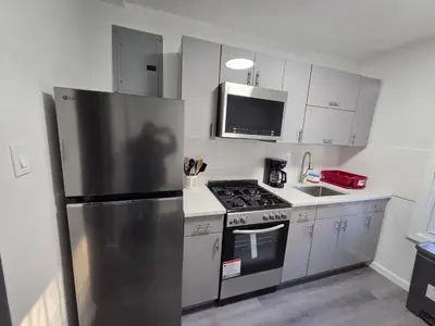 a kitchen with a stainless steel refrigerator and a stove at Grand Central & Times Square in 25-30 mins!! in Corona
