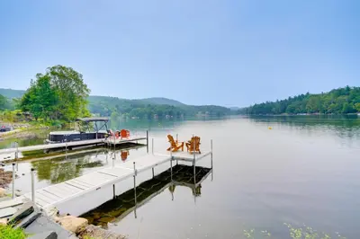 a dock with a boat on a lake at Cabin on Crooked Lake Ski, Skate and Explore! in Averill Park