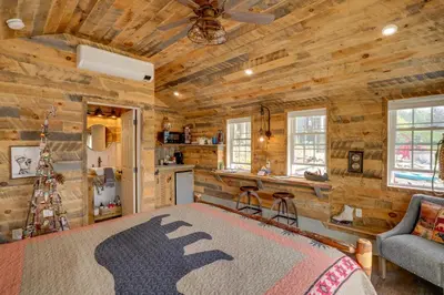 a log cabin bedroom with a bed and a couch at Cabin on Crooked Lake Ski, Skate and Explore! in Averill Park