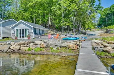 a house with a dock next to a body of water at Cabin on Crooked Lake Ski, Skate and Explore! in Averill Park