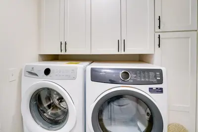 a washer and dryer in a kitchen with white cabinets at Ski, Skate and Explore Ultimate Winter Getaway! in Averill Park