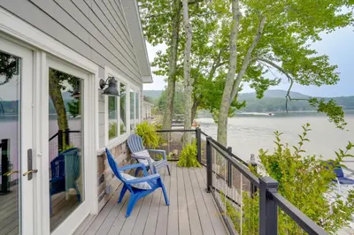 a porch with two blue chairs and a view of the water at Ski, Skate and Explore Ultimate Winter Getaway! in Averill Park