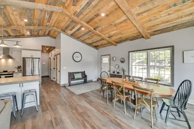 a kitchen and dining room with a table and chairs at Ski, Skate and Get Cozy Fireside Crooked Lake Home in Averill Park