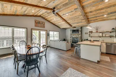 a kitchen and living room with a table and chairs at Ski, Skate and Get Cozy Fireside Crooked Lake Home in Averill Park