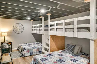 a bedroom with two bunk beds and a clock at Ski, Skate and Get Cozy Fireside Crooked Lake Home in Averill Park