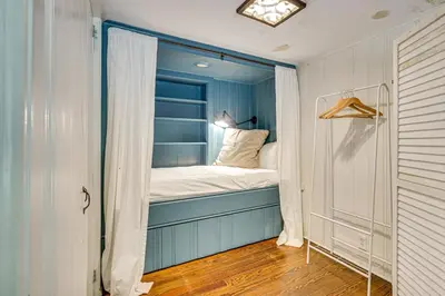 a small bedroom with a bed in a window at 15 Mi to Long Island Sound Bedford Winter Retreat in Bedford