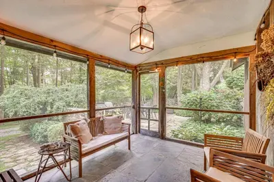 a screened in porch with a couch and a table at 15 Mi to Long Island Sound Bedford Winter Retreat in Bedford