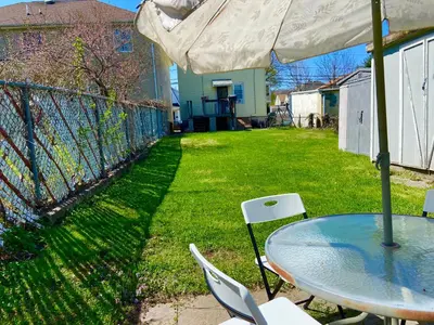 a patio with a table and chairs and an umbrella at Bright, Stylish and Comfortable Room with Workspace! in Haledon