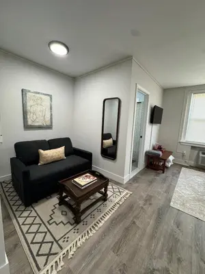 a living room with a black couch and a table at Yale Casa Blanco in New Haven