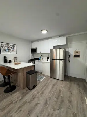 a kitchen with a stainless steel refrigerator and a table at Yale Casa Blanco in New Haven