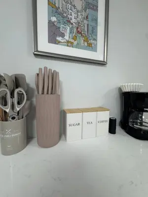 a counter with two containers of scissors and a picture at Yale Casa Baya in New Haven
