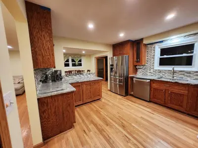 a large kitchen with wooden cabinets and stainless steel appliances at 3 Bed 2 Bath, Near UAlbany & MVP Arena, Private Driveway Parking in Albany