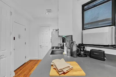 a kitchen with a wooden cutting board on a counter at Spacious SoHo 1Bedroom Unit Washer & Dryer in New York