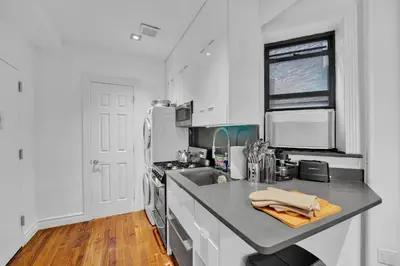 a white kitchen with a sink and a stove at Spacious SoHo 1Bedroom Unit Washer & Dryer in New York