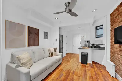 a living room with a couch and a kitchen at Spacious SoHo 1Bedroom Unit Washer & Dryer in New York