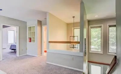 a living room with a fireplace and a chandelier at Hot tub, Sauna, fire pit, games and nature in Lake Poconos in Pocono Summit