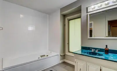 a bathroom with a tub and a sink and a mirror at Hot tub, Sauna, fire pit, games and nature in Lake Poconos in Pocono Summit