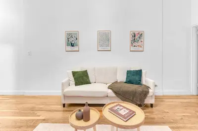 a living room with a white couch and a table at Inviting 2Bd Upper East Side Stay with Backyard in New York