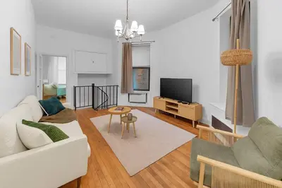 a living room with a white couch and a tv at Inviting 2Bd Upper East Side Stay with Backyard in New York