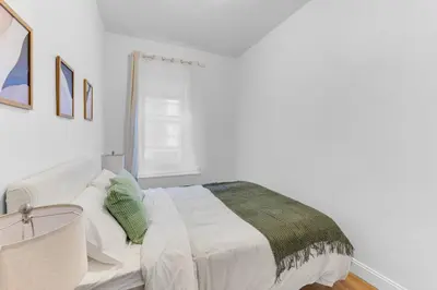a white bedroom with a bed and a window at Inviting 2Bd Upper East Side Stay with Backyard in New York