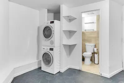 a bathroom with two washing machines and a toilet at Inviting 2Bd Upper East Side Stay with Backyard in New York