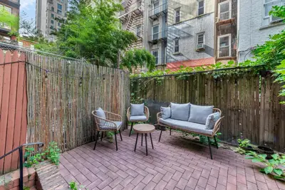 a patio with two chairs and a couch and a table at Inviting 2Bd Upper East Side Stay with Backyard in New York