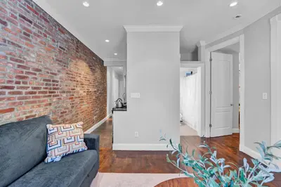 a brick wall in a living room with a couch at Gramercy Apartment - 3BR 2BA Modern Central in New York