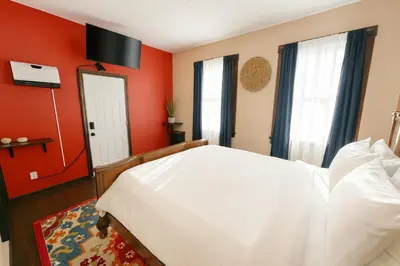 a bedroom with a white bed and red walls at The Sicilian at Elm City Flats in New Haven