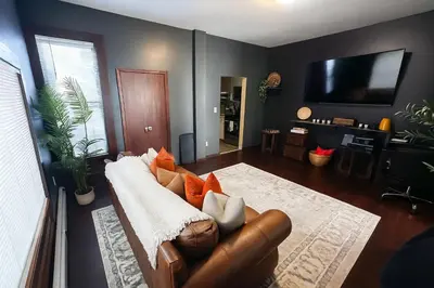 a living room with a couch and a television at The Sicilian at Elm City Flats in New Haven