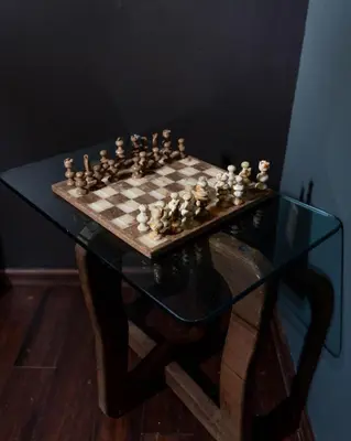 a chess board on a glass table with a chessboard at The Sicilian at Elm City Flats in New Haven