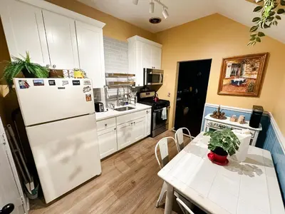 a kitchen with a white refrigerator and a table at The Sicilian at Elm City Flats in New Haven