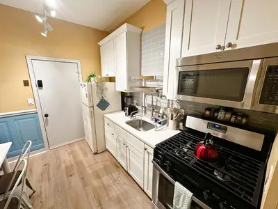 a kitchen with a stove and a sink at The Sicilian at Elm City Flats in New Haven