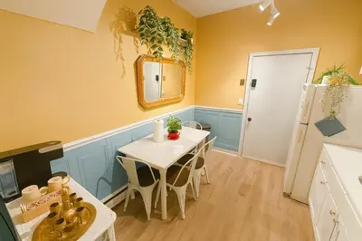 a kitchen with a table with chairs and a mirror at The Sicilian at Elm City Flats in New Haven