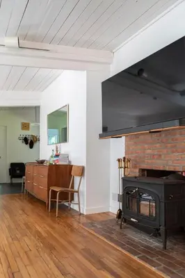 a living room with a fireplace and a table at Gunn Brook Mountain House in Cornwall