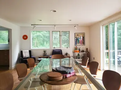 a living room with a glass table and chairs at Gunn Brook Mountain House in Cornwall