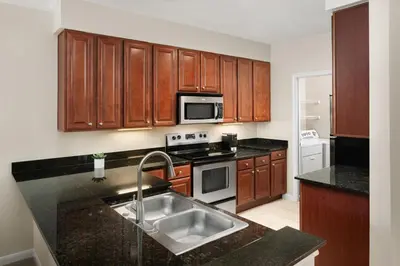 a kitchen with wooden cabinets and a stainless steel sink at AVE Clifton - Furnished Apartment, Clifton NJ in Clifton