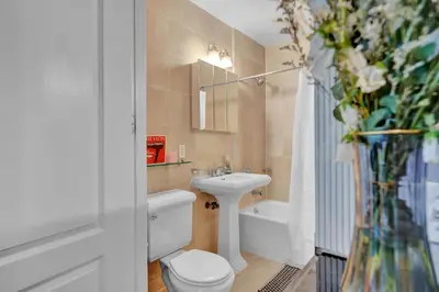 a bathroom with a toilet and a sink and a tub at Elegant 3BR-2BA in Gramercy -Modern & Central in New York