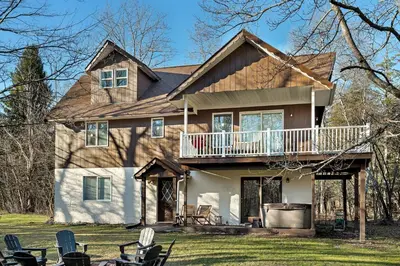 a large house with a porch and a deck at Luxury Mountain Getaway - 6 bed, 3 bath, hot-tub, fire-pit, game-room in Hunter