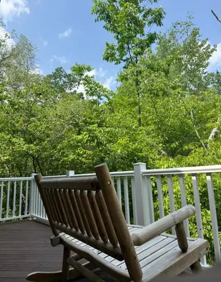 a wooden bench sitting on a wooden deck at Luxury Mountain Getaway - 6 bed, 3 bath, hot-tub, fire-pit, game-room in Hunter