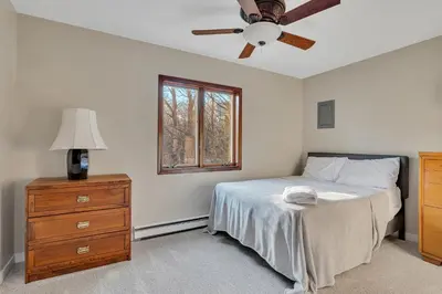 a bedroom with a bed with a ceiling fan and a dresser at Luxury Mountain Getaway - 6 bed, 3 bath, hot-tub, fire-pit, game-room in Hunter