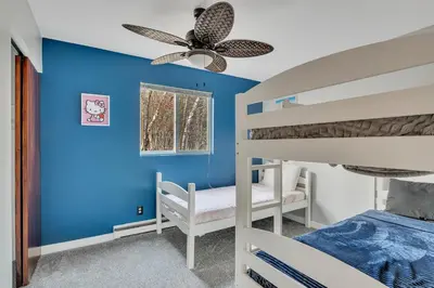 a bedroom with two bunk beds and a blue wall at Luxury Mountain Getaway - 6 bed, 3 bath, hot-tub, fire-pit, game-room in Hunter