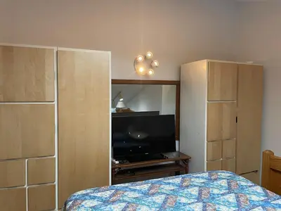 a bedroom with a bed and a flat screen tv at Cozy Downtown Hunter Mountain Getaway in Hunter