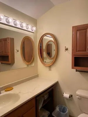 a bathroom with a sink and two mirrors at Cozy Downtown Hunter Mountain Getaway in Hunter