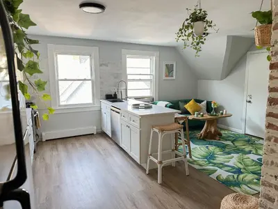 a kitchen with a sink and a table in a room at The Nest At Elm City Flats in New Haven