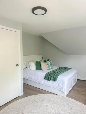 a bedroom with a white bed with pillows on it at The Nest At Elm City Flats in New Haven