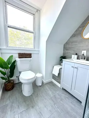 a bathroom with a toilet and a sink and a window at The Nest At Elm City Flats in New Haven