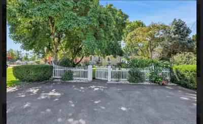 a white picket fence in a yard with a tree at Charming Home on Esopus Creek in Saugerties