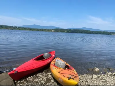 two kayaks sitting on the shore of a lake at Charming Home on Esopus Creek in Saugerties