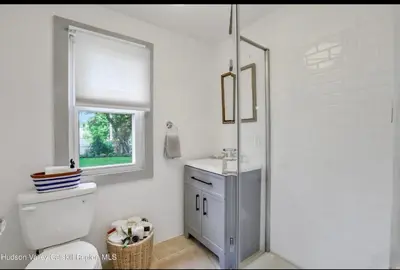a bathroom with a toilet and a sink and a window at Charming Home on Esopus Creek in Saugerties