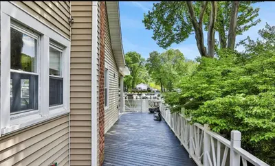 a house with a wooden walkway next to a window at Charming Home on Esopus Creek in Saugerties